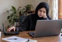 connected-to-network-but-no-internet-access-fix Person checking a wireless router while troubleshooting a Wi-Fi connected but no internet access issue at home